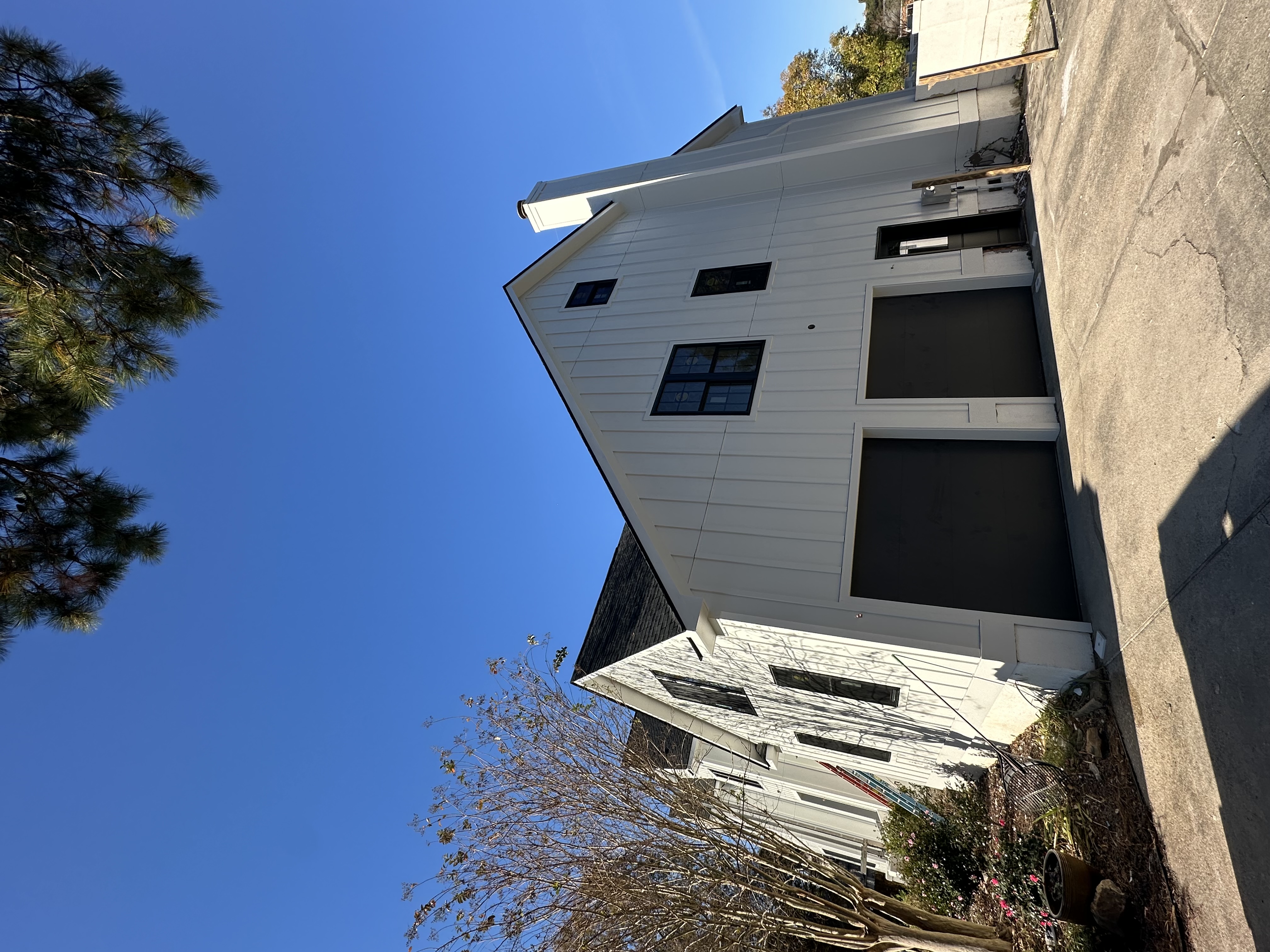 Modern farmhouse with white board-and-batten siding and black windows