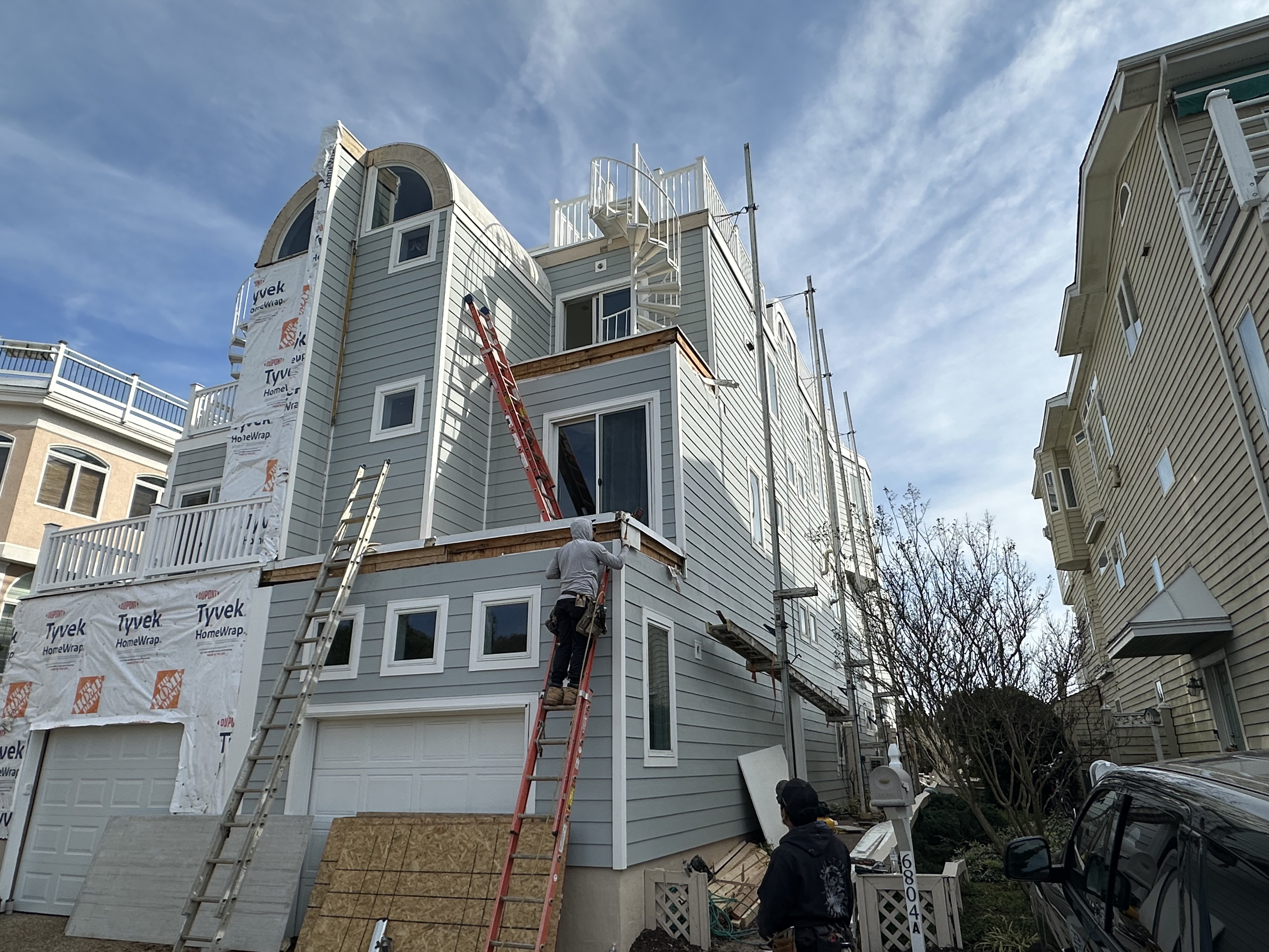 Smart Siding Exteriors crew member working on a coastal home exterior